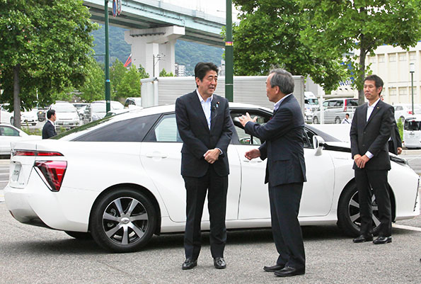 MIRAIの前でトヨタ内山田会長より説明を受ける安部首相