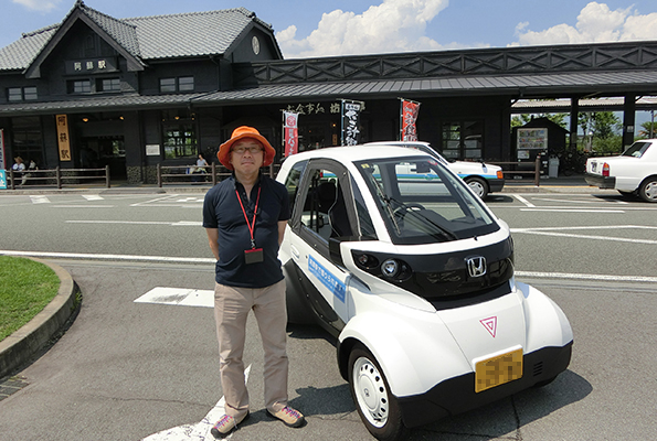 超小型モビリティ、ホンダ「MC-β」。阿蘇駅前でレンタル。お話を聞いた、阿蘇市観光協会の事務局長、松永辰博氏。