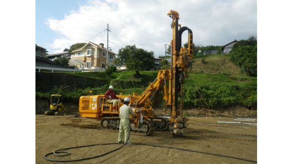 【岩盤地への先行掘削】専用掘削機により岩盤へ先行掘削を行いピンポイントで穴をあける。