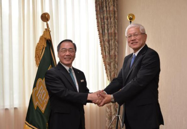 固い握手を交わす松尾総長（左）と松井社長（右）