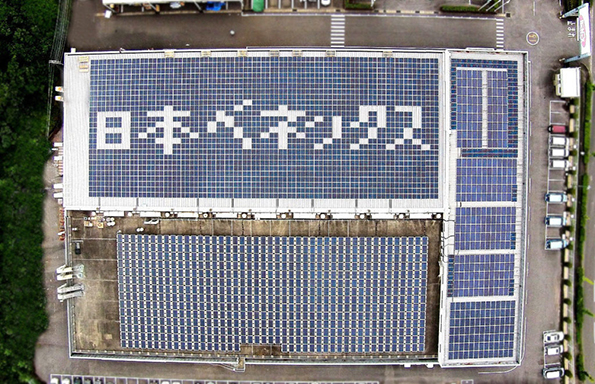本社工場の屋根に社名を形どった太陽光パネルを配置