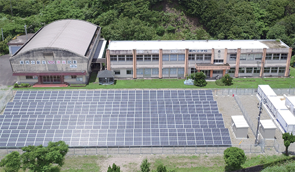廃校の校庭に100kWの太陽光発電設備と 日産リーフ36台分のバッテリーを再利用した蓄電池設備を設置（似島）