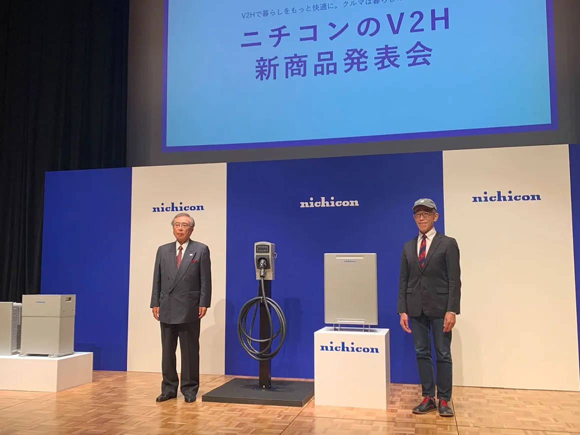 ニチコンの代表取締役会長 武田一平氏(左)と新商品発表会でゲスト登壇した慶應義塾大学大学院教授 岸博幸氏(右)